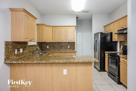 a kitchen with granite counter tops and black appliances