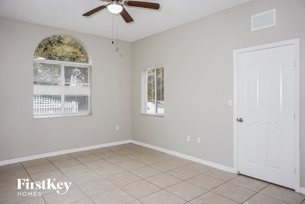 an empty room with a white door and a ceiling fan