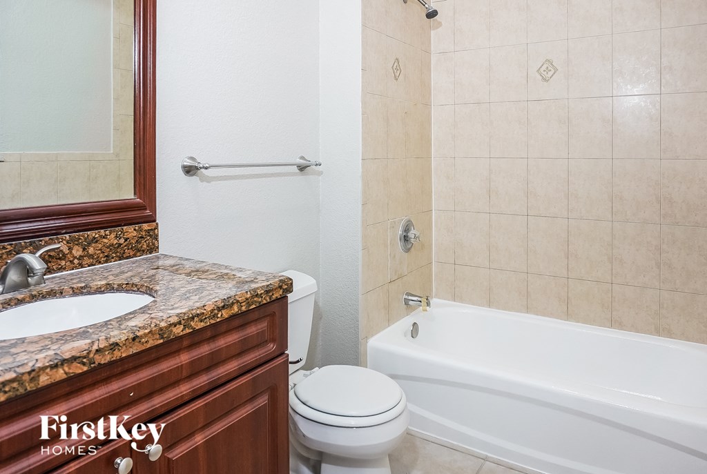 a bathroom with a toilet and a tub and a sink