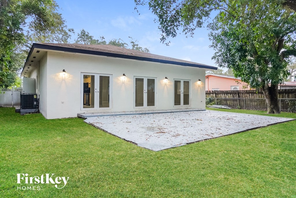 a small white house with a yard and a patio