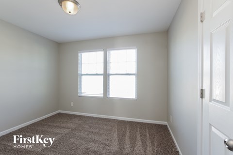 a bedroom with a carpeted floor and two windows