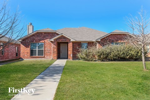 a brick house with a sidewalk in front of it