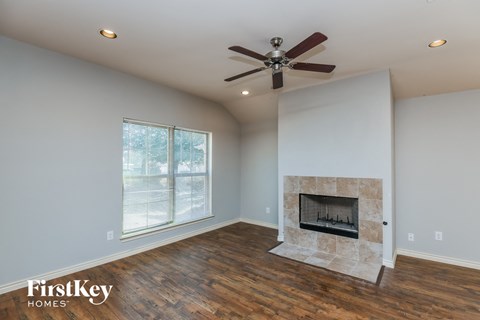 a living room with a fireplace and a ceiling fan
