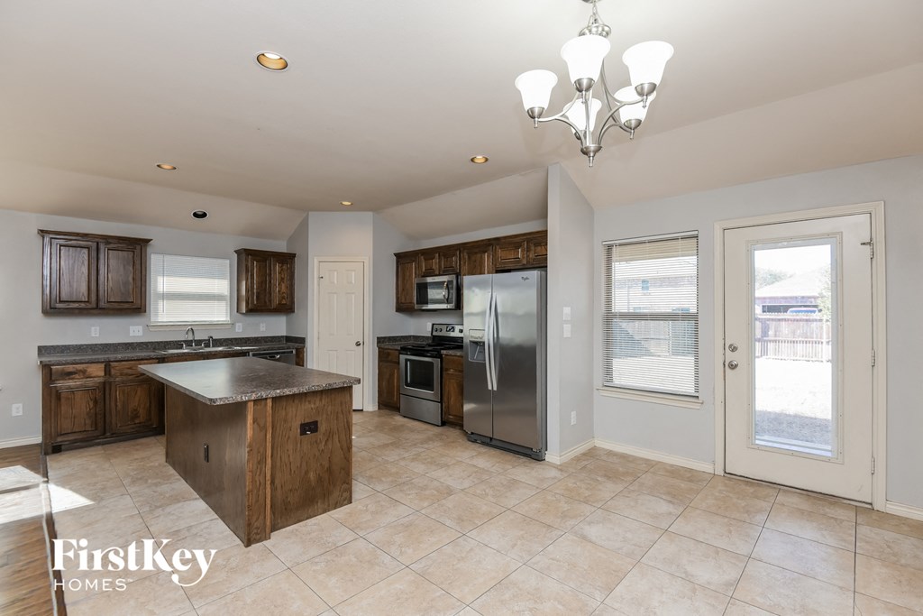 a large kitchen with stainless steel appliances and wooden cabinets
