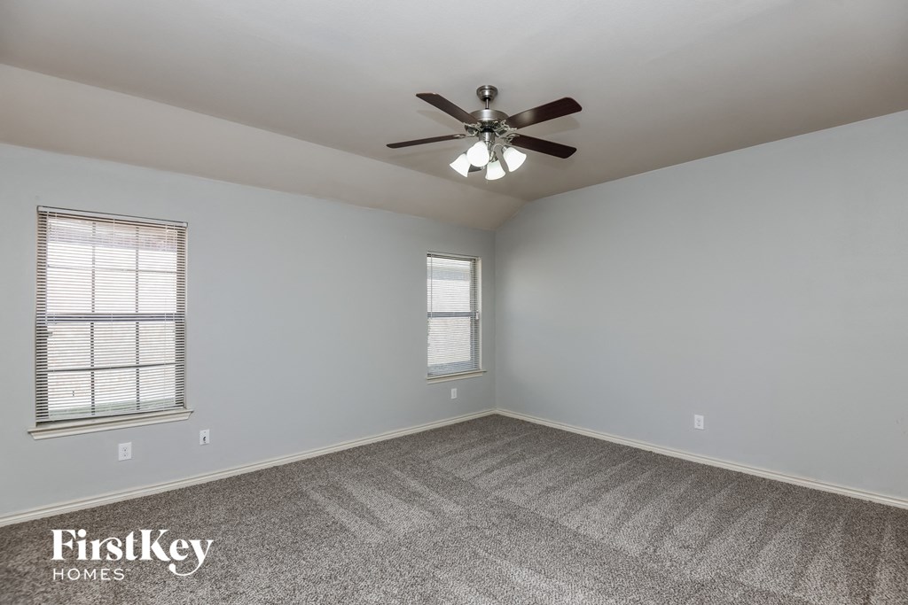 an empty room with a ceiling fan and a window