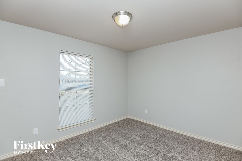 a bedroom with a carpeted floor and a large window