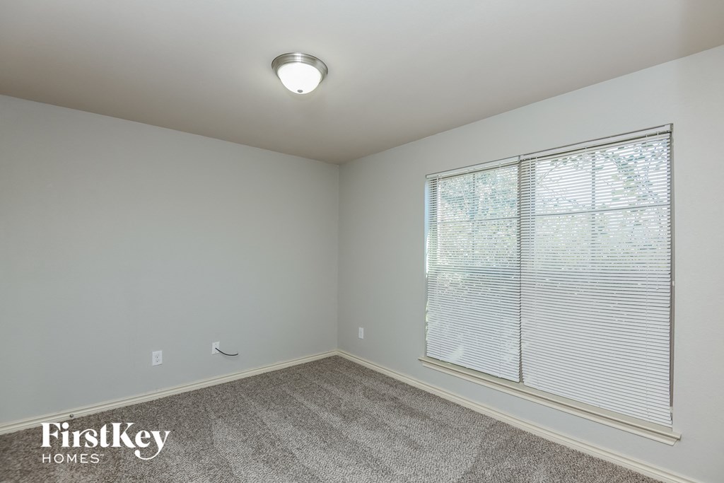 the living room has a large window and carpeted flooring