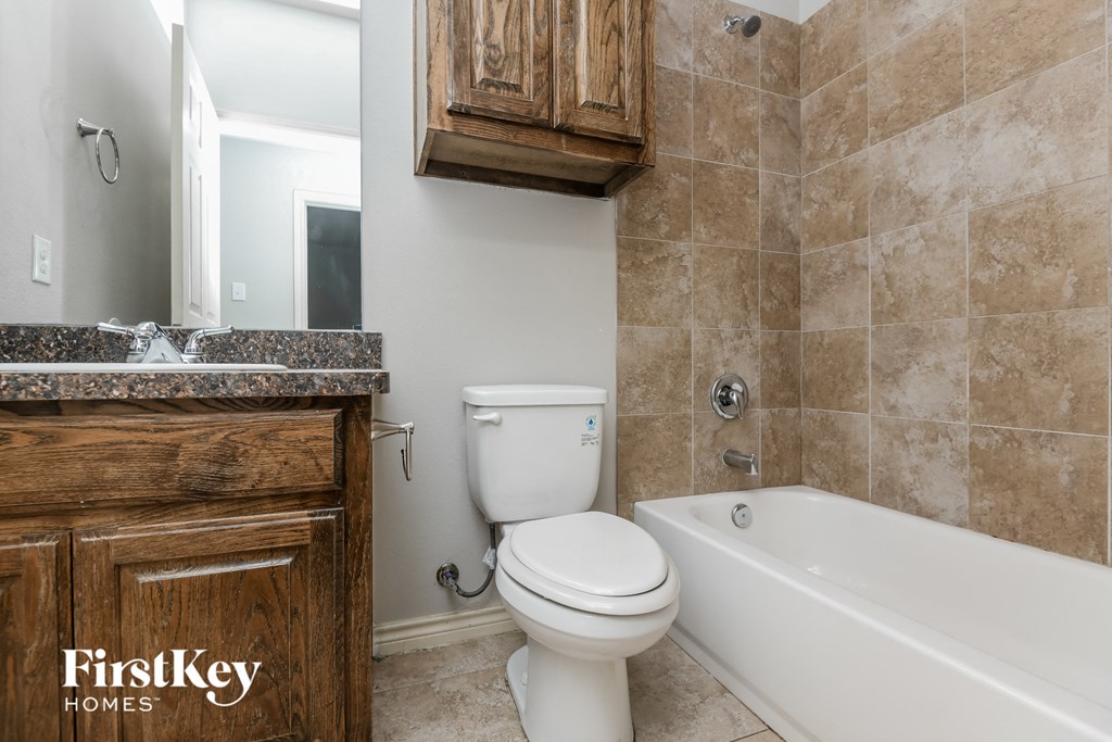 a bathroom with a toilet and a tub and a sink