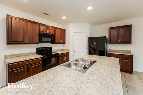 a kitchen with granite counter tops and black appliances