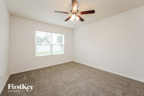 a living room with a ceiling fan and a window