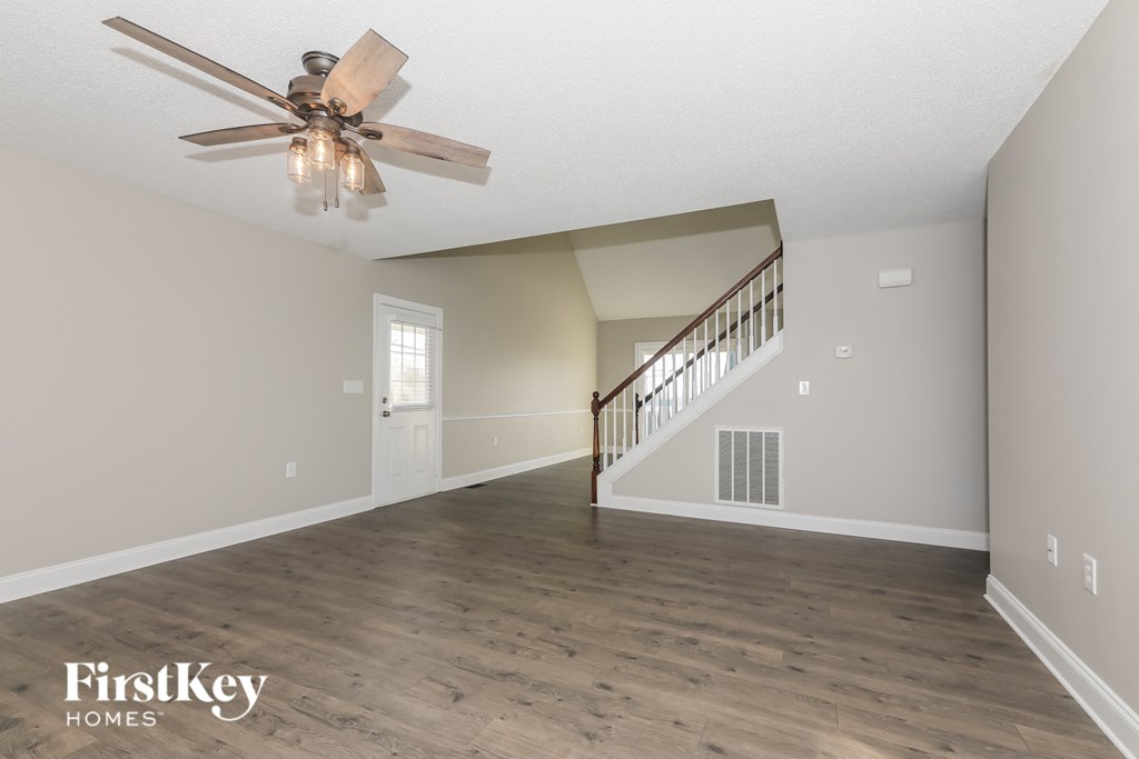 A spacious room with a staircase leading to the upper floor.