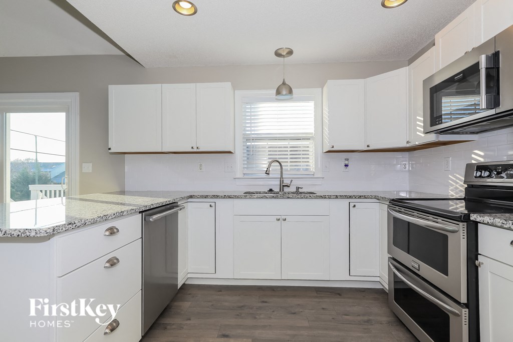 A kitchen with white cabinets and stainless steel appliances.
