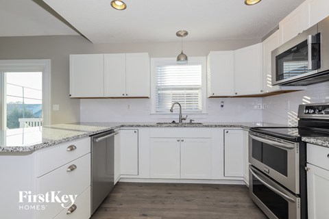 A kitchen with white cabinets and stainless steel appliances.