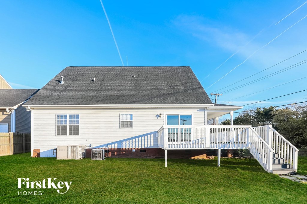 A house with a white exterior and a grey roof is for sale by FirstKey Homes.