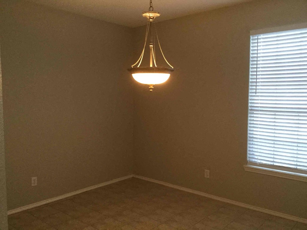 an empty room with a light hanging from the ceiling