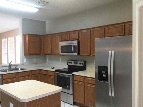 a kitchen with stainless steel appliances and wooden cabinets