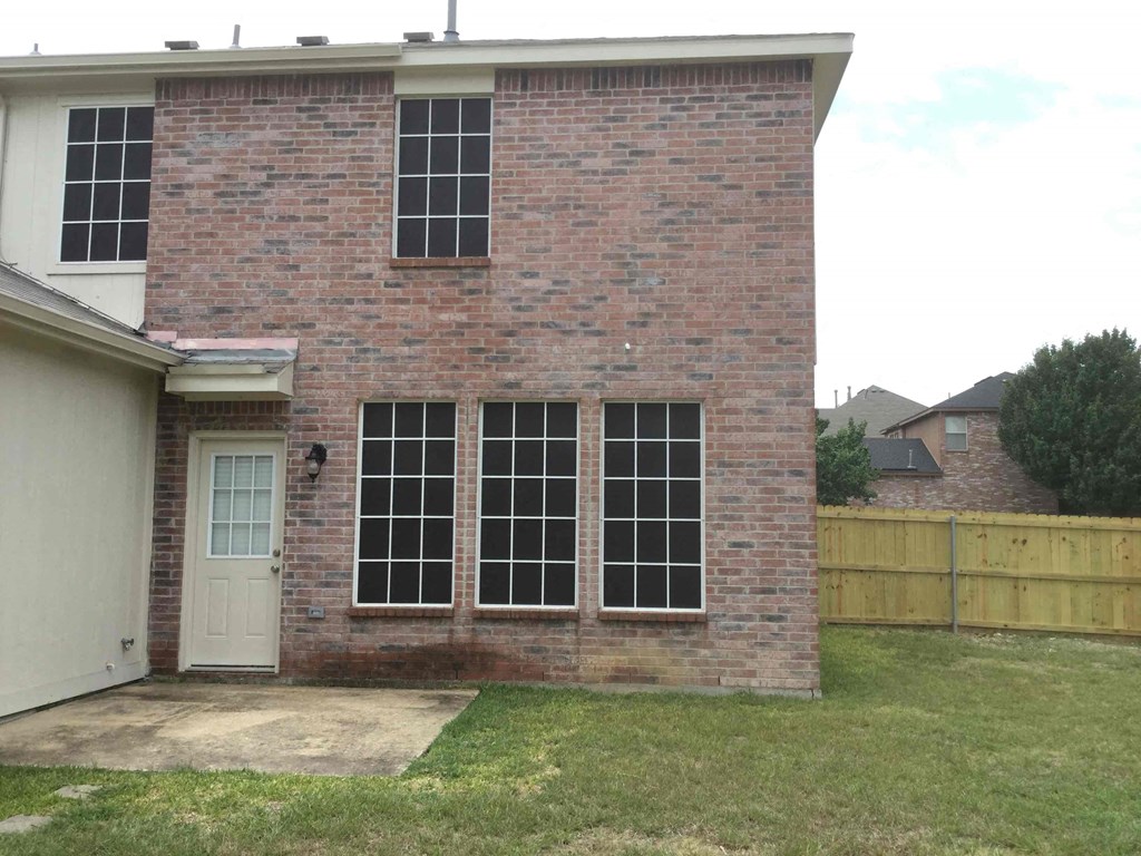 a brick house with windows and a white door