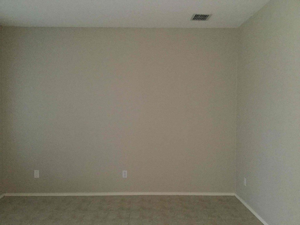 an empty room with beige walls and a tan floor