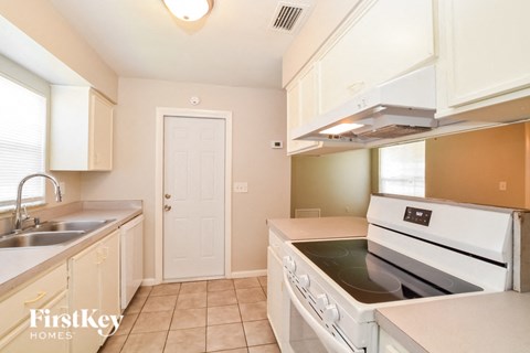 A kitchen with a stove top oven and a sink.