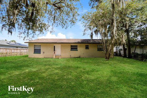 A house with a lawn and trees in front of it.
