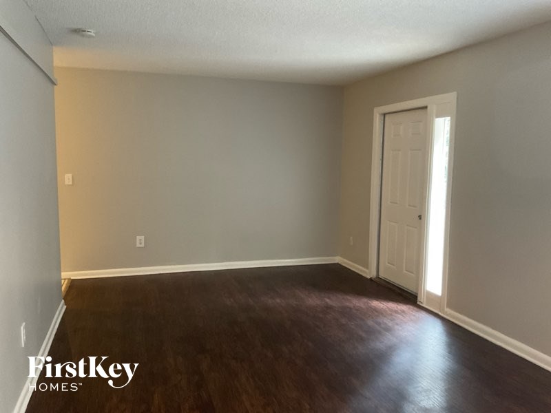 A room with a wooden floor and a white door.