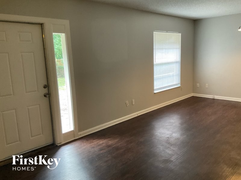 A room with a wooden floor and a white door.