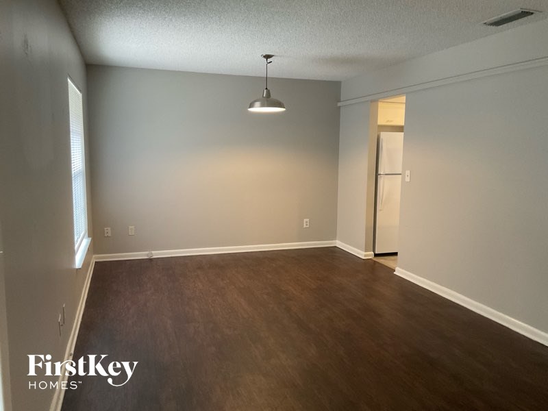 A room with wooden floors and a light fixture hanging from the ceiling.