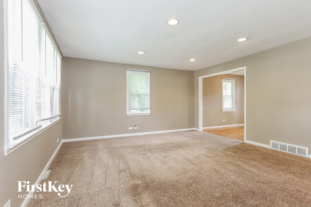 a living room with a carpeted floor and a large window