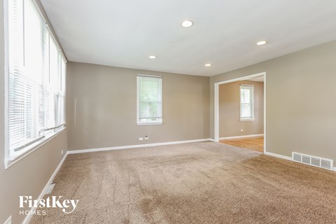 a living room with a carpeted floor and a large window