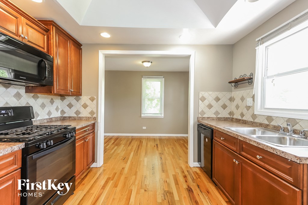 a kitchen with wooden cabinets and a stove top oven and a sink