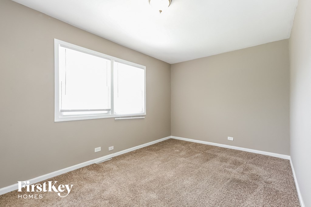 a bedroom with a carpeted floor and two windows
