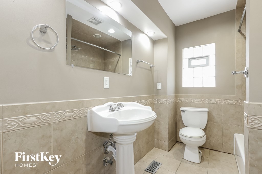 a bathroom with a sink toilet and a mirror