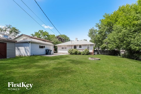 a backyard with a house and a yard with grass and a fence