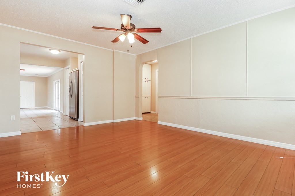A room with wooden floors and a ceiling fan.