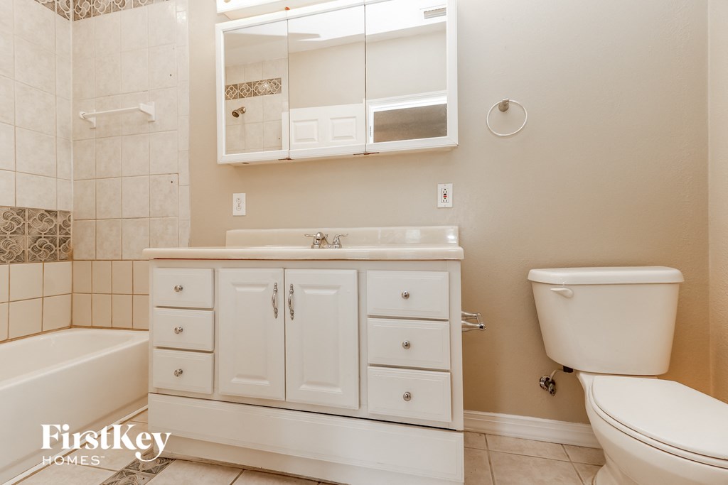 A white bathroom with a tub, sink, and toilet.