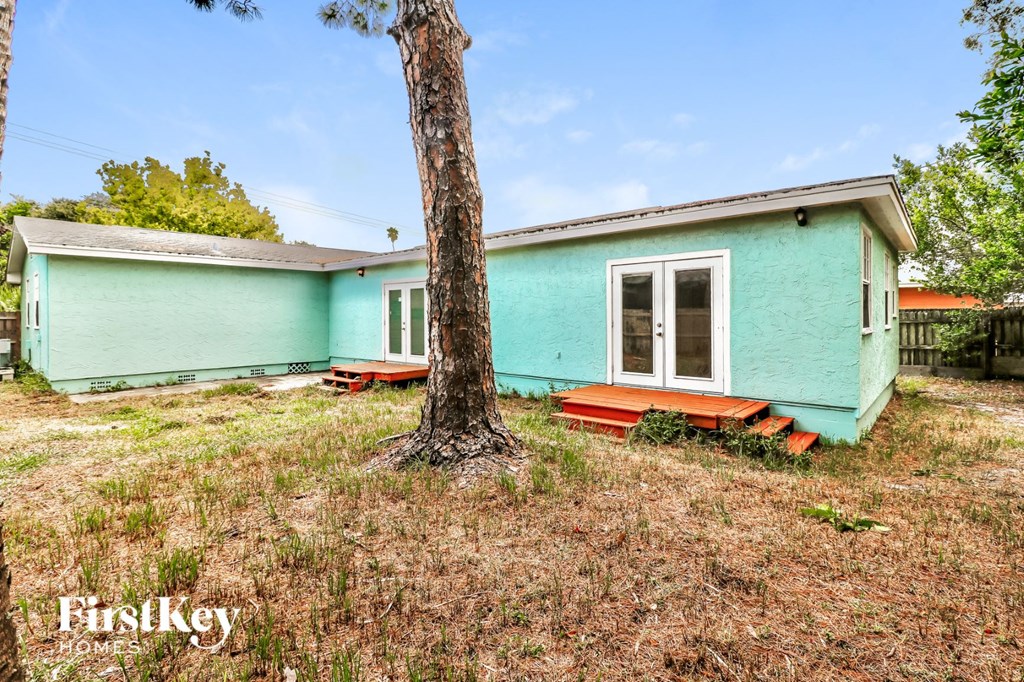 A blue house with a tree in front of it.