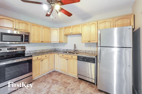 A kitchen with wooden cabinets and a stainless steel refrigerator.