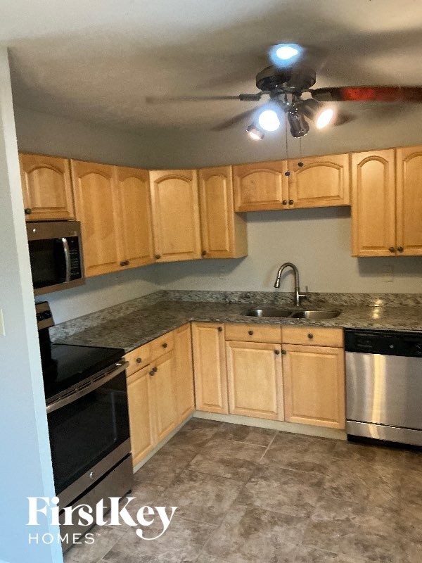A kitchen with wooden cabinets and a stainless steel dishwasher.