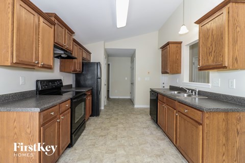 A kitchen with wooden cabinets and a black refrigerator.