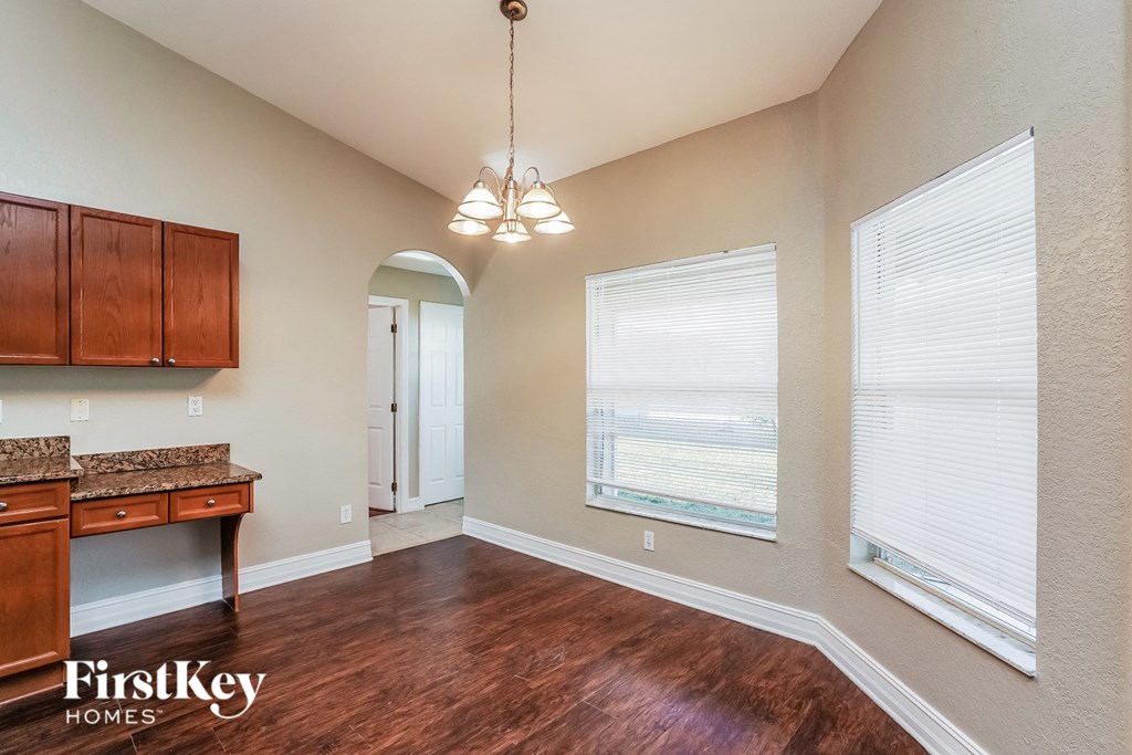 a kitchen and living room with wood flooring and large windows