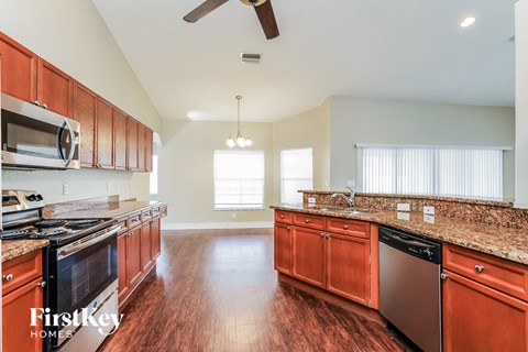 a kitchen with wooden cabinets and granite counter tops and stainless steel appliances