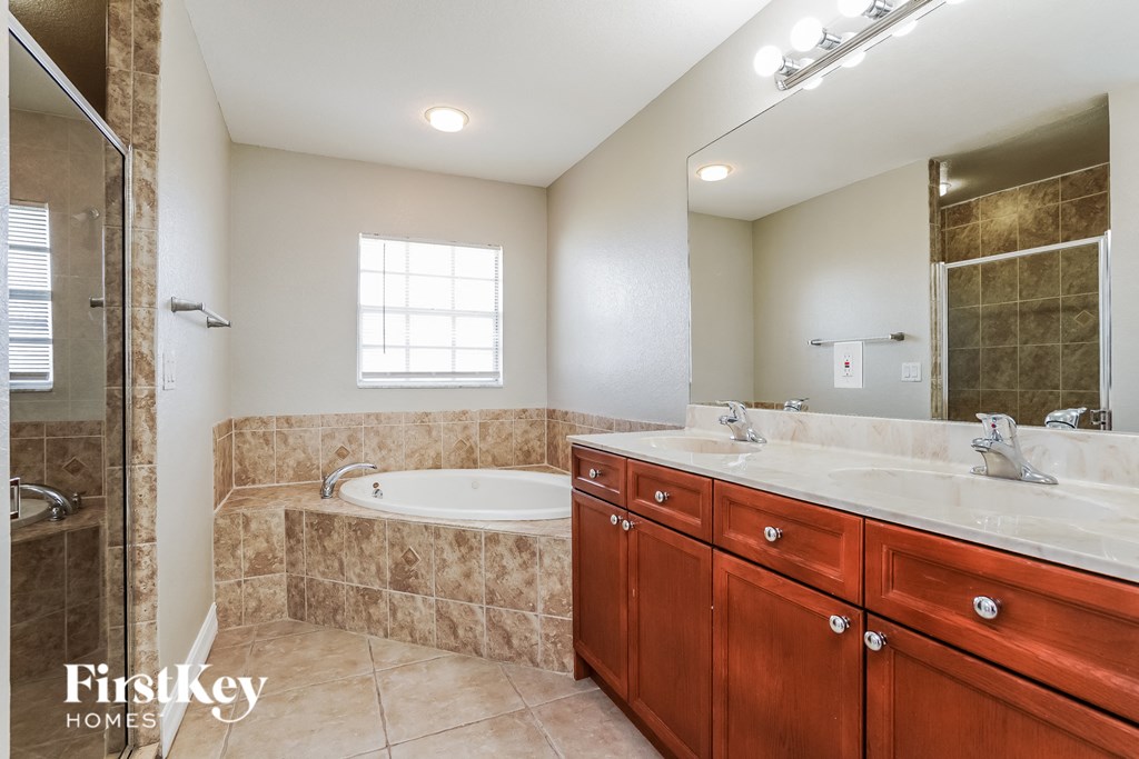 a bathroom with a tub and a sink and a mirror