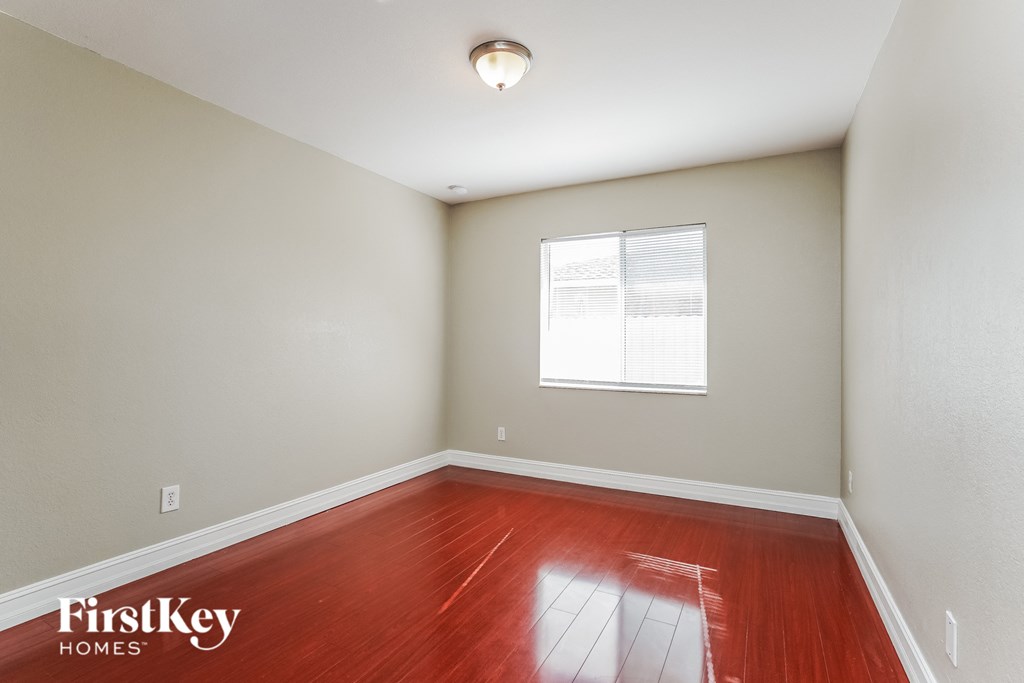 the living room with wood floors and a window
