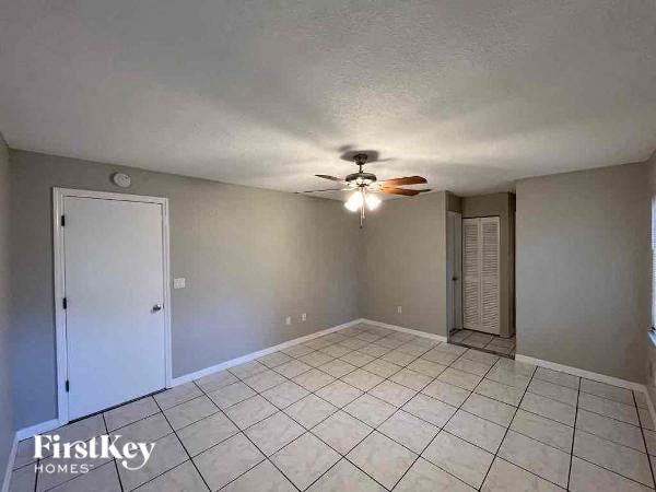 A room with a ceiling fan and tile flooring.