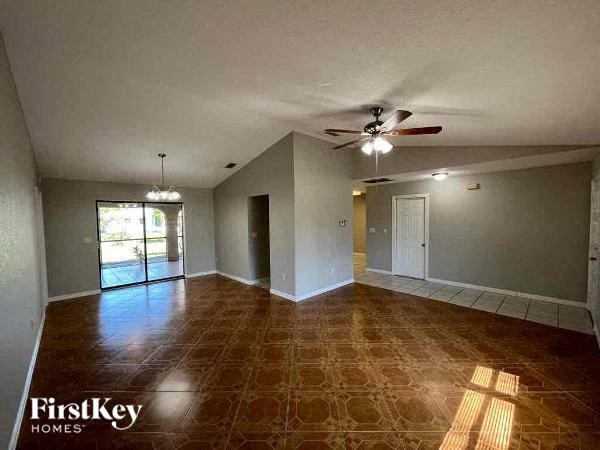 A room with a ceiling fan and a large window.