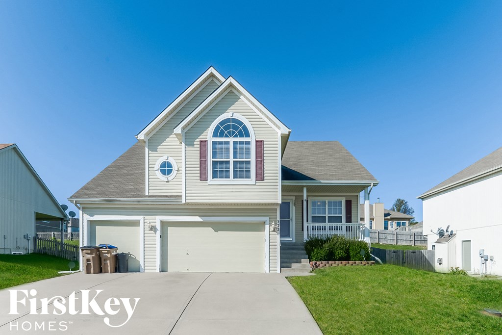 A house with a garage and a driveway in front of it.