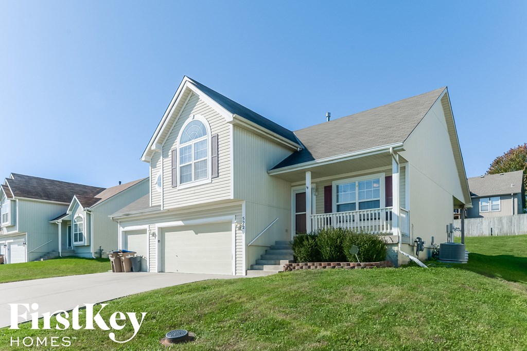 A house with a garage and a front porch is for sale.