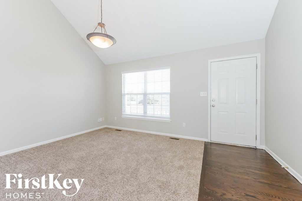 A room with a carpeted floor and a white door.