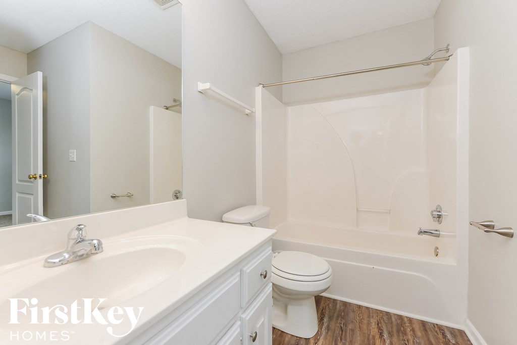 A white bathroom with a toilet, sink, and bathtub.