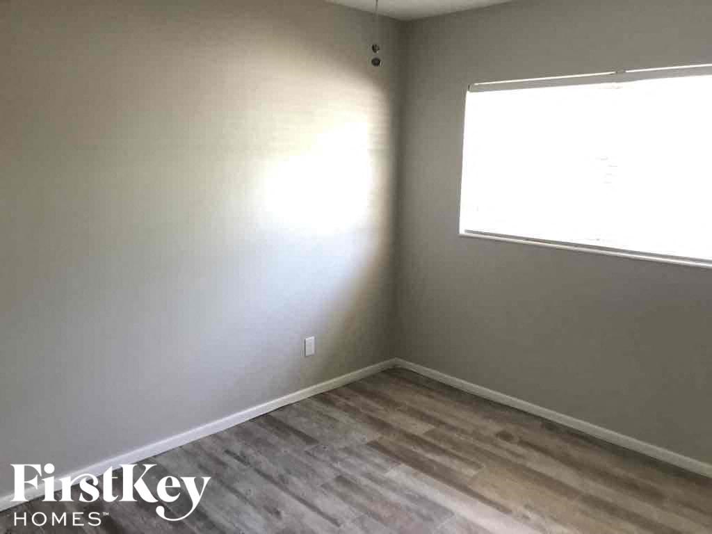 a empty room with a window and wooden floors